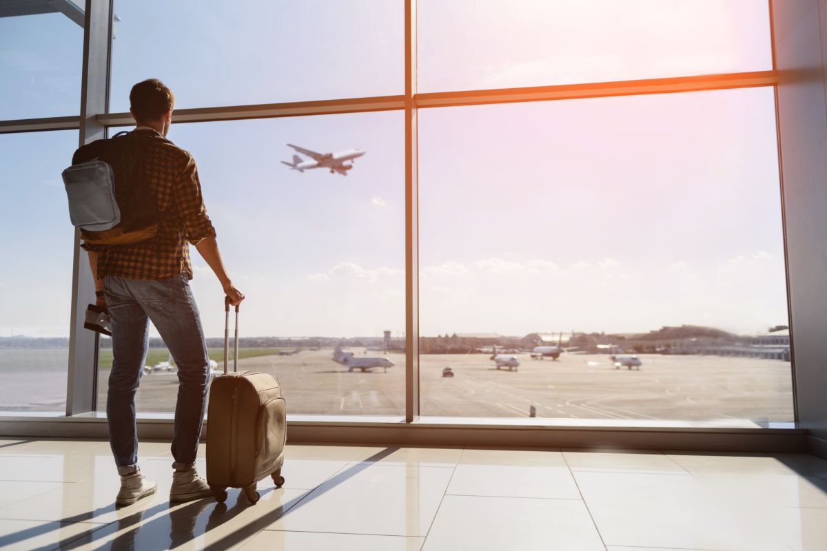 ragazzo con zaino e valigia in aeroporto, viaggio, viaggiare