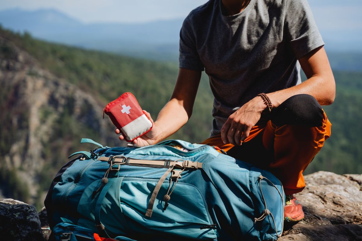 viaggiare sicuri, ragazzo con kit pronto soccorso in montagna