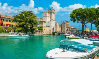 Veduta di Sirmione, Lago di Garda, Lombardia, con una barca in primo piano e il castello sullo sfondo