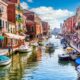 Vista di un canale dell'Isola di Murano a Venezia con barche ormeggiate ai lati