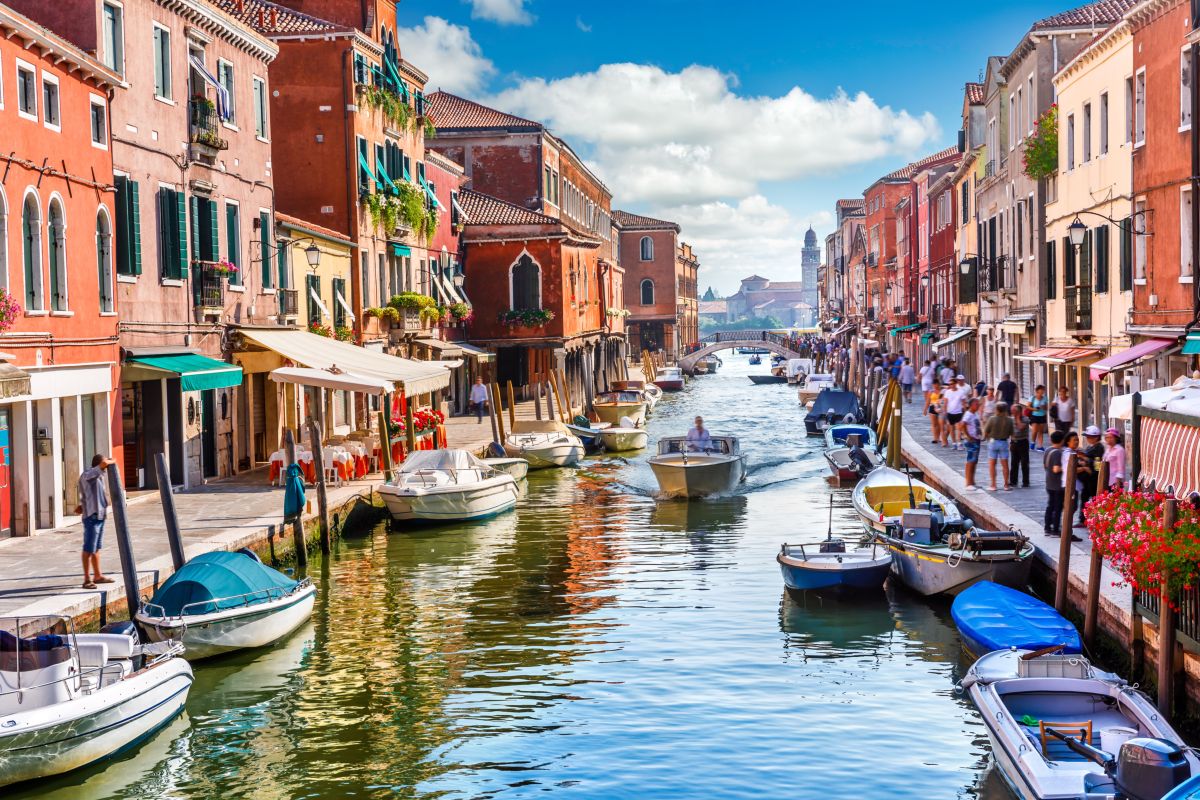 Vista di un canale dell'Isola di Murano a Venezia con barche ormeggiate ai lati