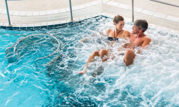 Una coppia di innamorati in una piscina con idromassaggio di una spa