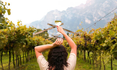 Ragazza in un vigneto che tiene tra le mani un calice di vino