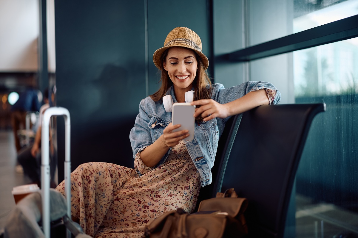 Donna al cellulare in attesa in aeroporto