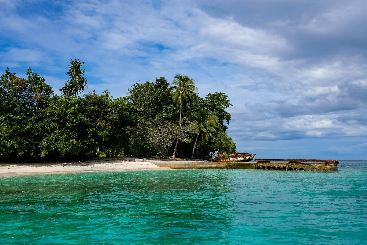 Immagine di una isola nell'Oceano, con spiaggia ed un piccolo porticciolo