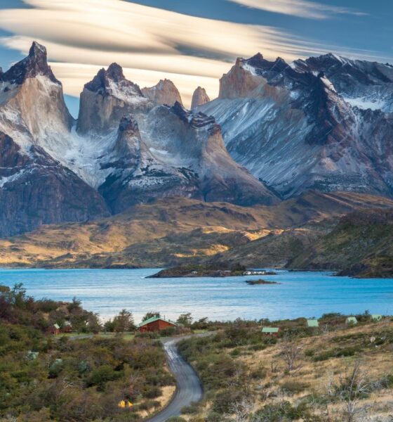Strada che attraversa la vallata e che porta verso un lago della Patagonia cilena con sullo sfondo delle montagne rocciose con della neve