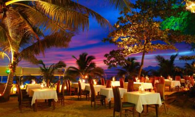 Ristorante al tramonto con tavoli sotto le palme