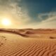 Veduta delle dune del deserto con il sole all'orizzonte