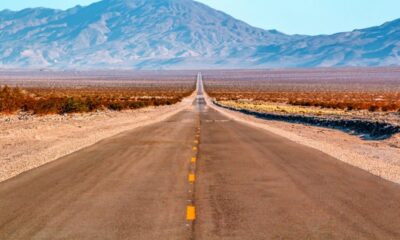 Strada che attraversa il deserto in California con sullo sfondo delle montagne