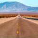 Strada che attraversa il deserto in California con sullo sfondo delle montagne