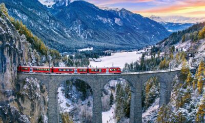 Treno che transita sul ponte Filisur in Svizzera con sullo sfondo le montagne alpine