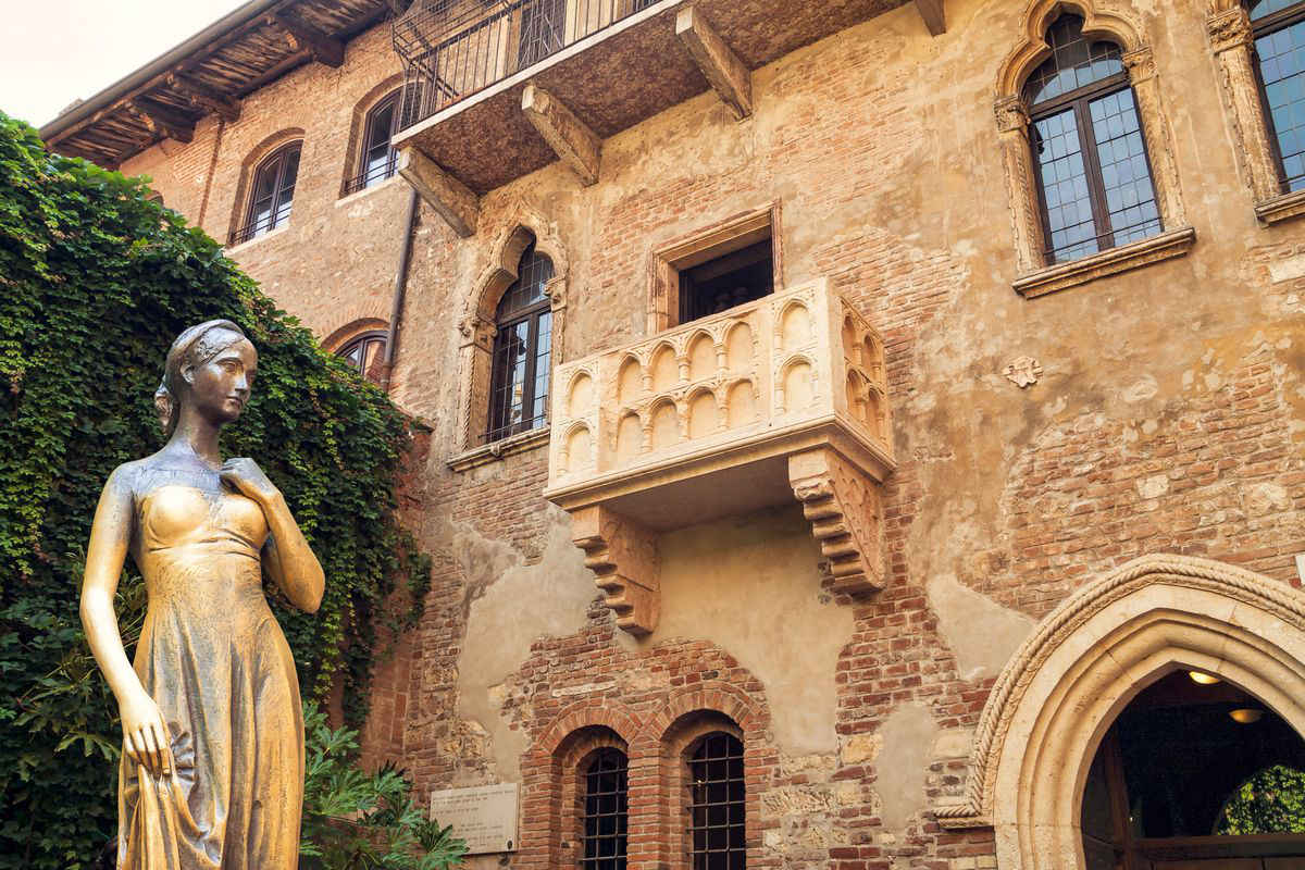 Verona, Casa di Giulietta con la statua a lei dedicata in primo piano e il famoso balcone.