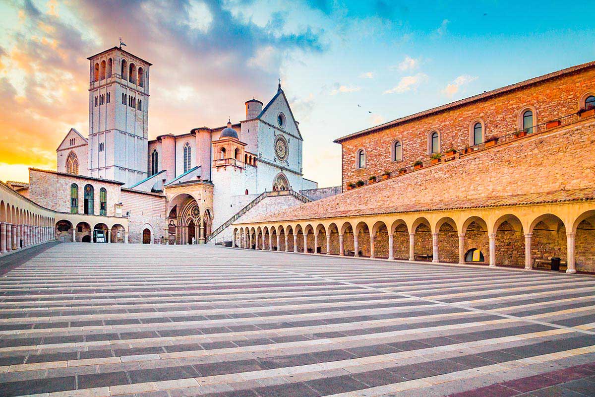 Vista in primo piano della scalinata che porta alla basilica di san Francesco ad Assisi al tramonto