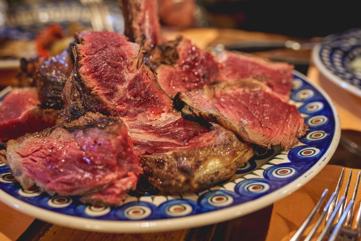 Le fette di carne di una bistecca alla fiorentina su un piatto decorato