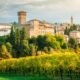 Veduta panoramica del castello di Levizzano con un frutteto in primo piano