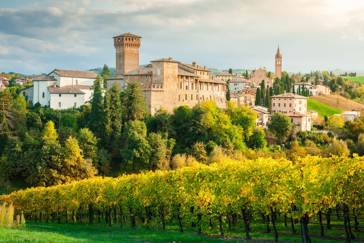 Veduta panoramica del castello di Levizzano con un frutteto in primo piano