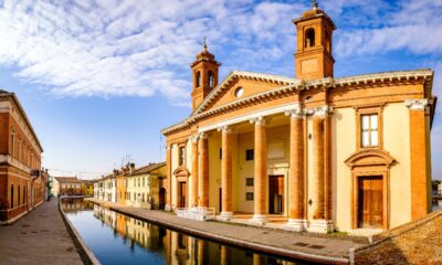 La basilica concattedrale di San Cassiano Martire, con la facciata riflessa nelle acque del canale prospicente in una giornata di sole