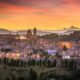 Una vista su Urbino al tramonto con il borgo illuminato