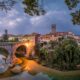 Vista di Cividale del Friuli all'imbrunire con in primo piano il fiume Natisone e il Ponte del Diavolo illuminato