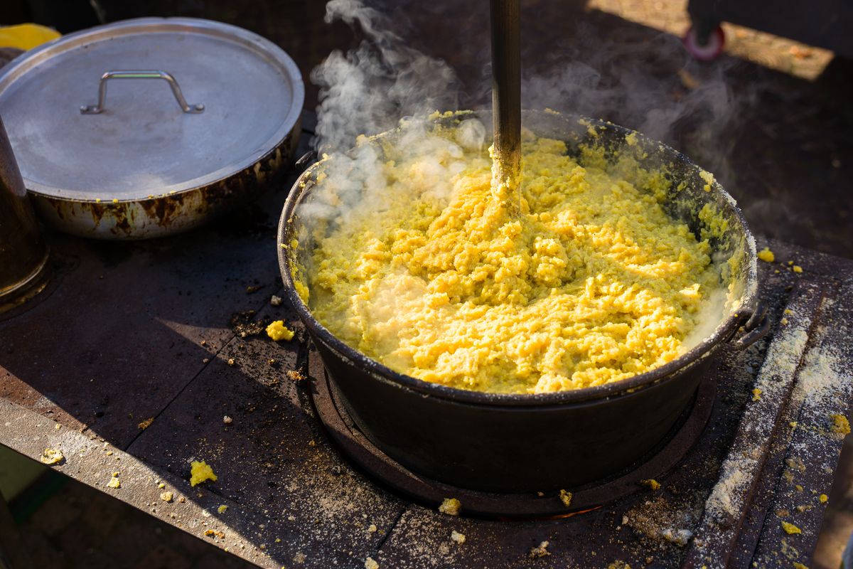 Un paiolo di polenta cuoce sul fuoco