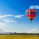 Mongolfiera in volo sopra i campi