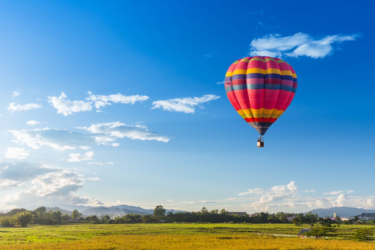 Mongolfiera in volo sopra i campi