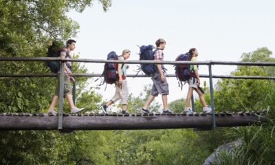 Ragazzi che attraversano un ponte di legno zaini in spalla