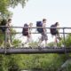 Ragazzi che attraversano un ponte di legno zaini in spalla