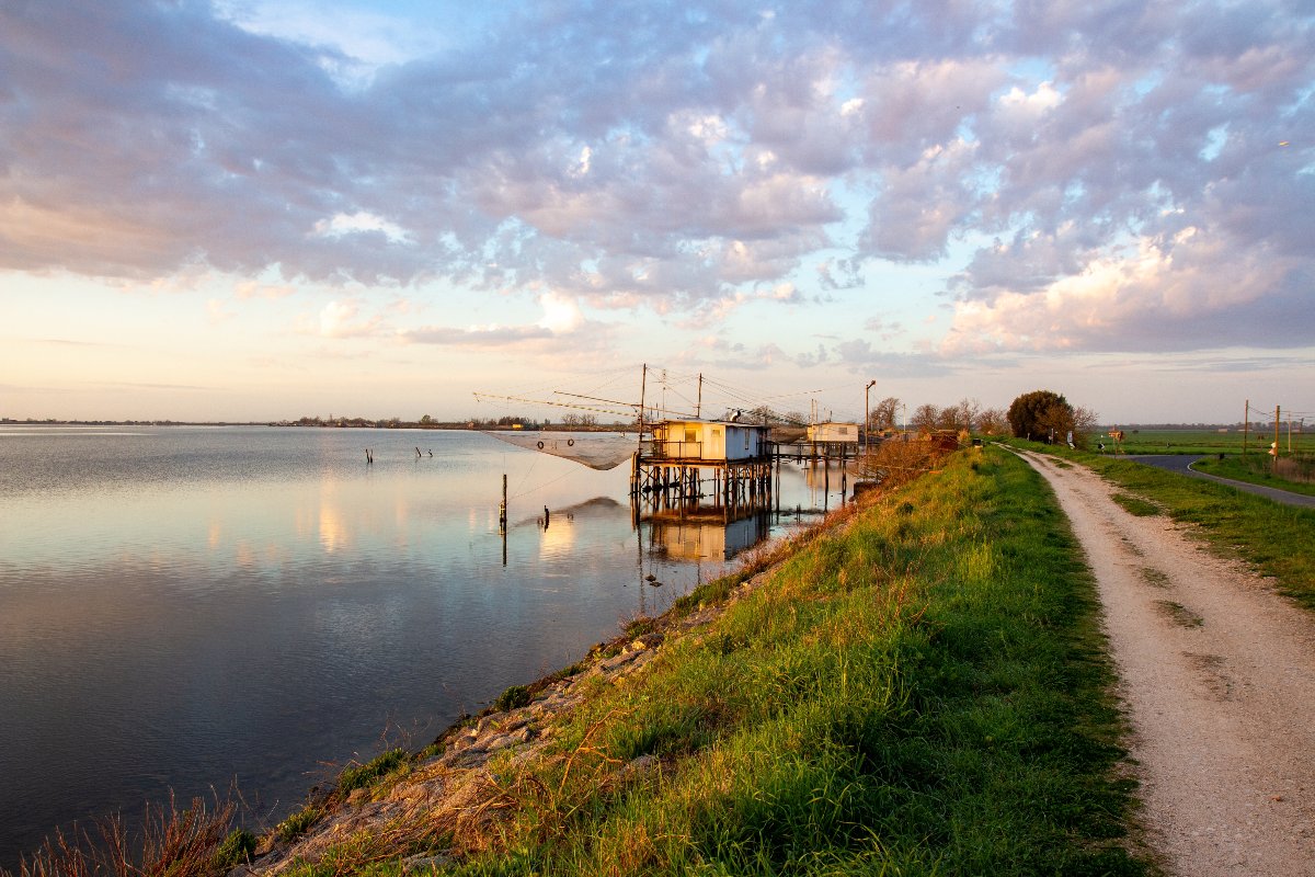 Panorama della laguna di Comacchio al tramonto con una rete da pesca in secondo piano