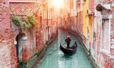 Una gondola in uno degli stretti canali di Venezia illuminato dal sole