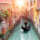 Una gondola in uno degli stretti canali di Venezia illuminato dal sole